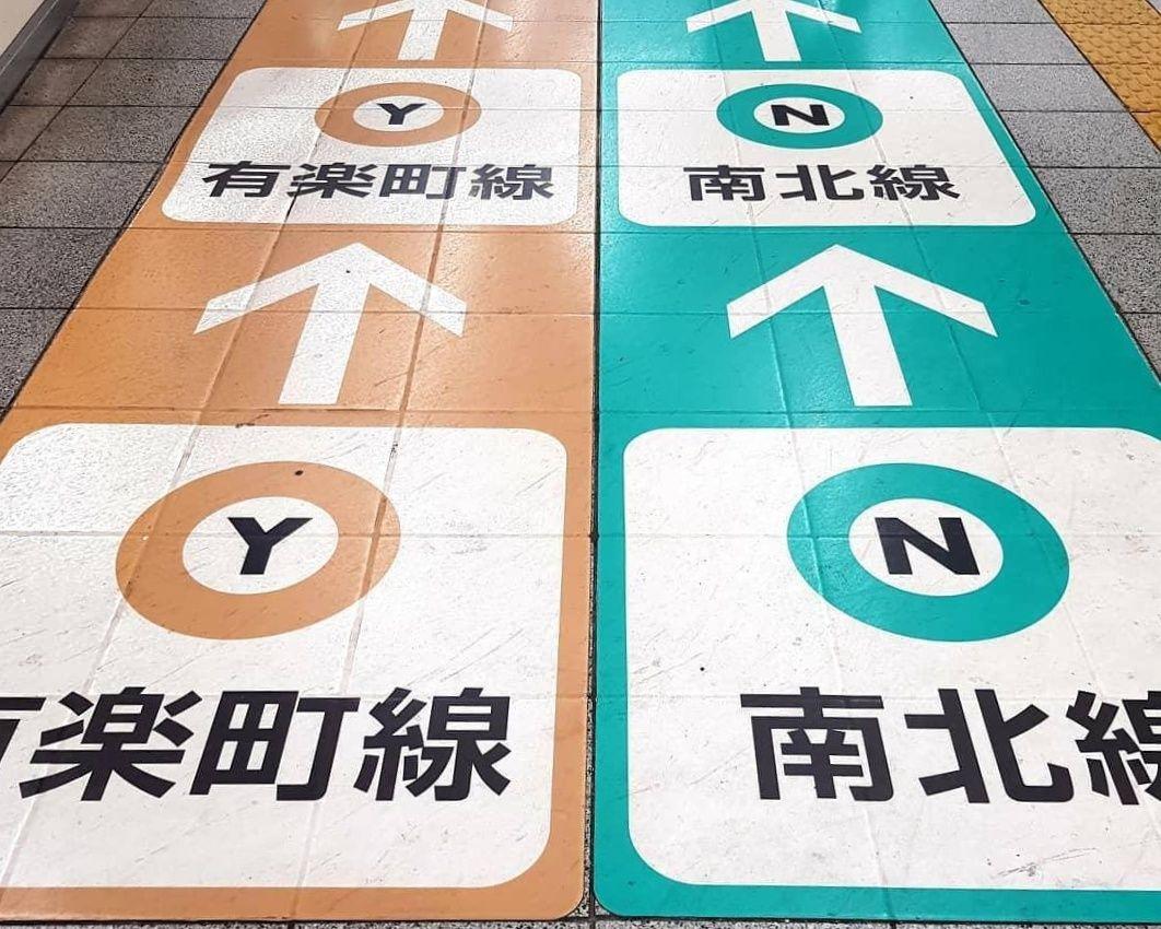 Colour-coded arrows on the floor in a Tokyo train station