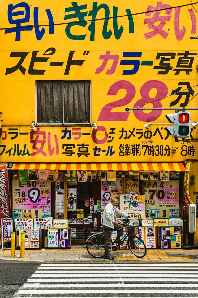 Useful Japanese tips - man waiting to cross the road outside a drug store in Japan