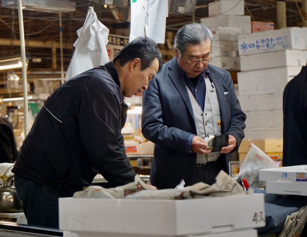 Japan travel tips - 2 men in a fish market