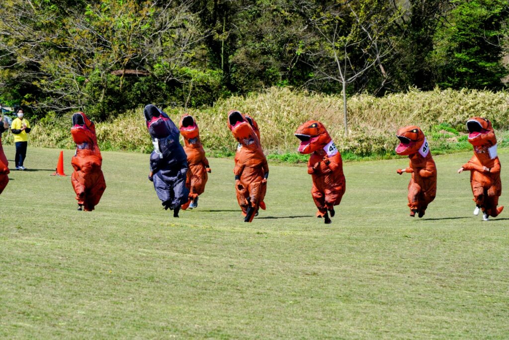 Dinosaur race in Japan - runners in t-rex suits sprinting 