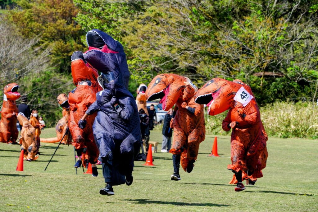 Dinosaur race in Japan - runners in t-rex suits sprinting 
