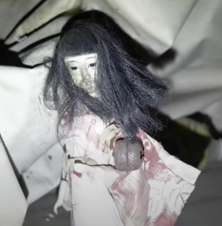 Abandoned places in Japan - a Japanese doll with a bell around its waist